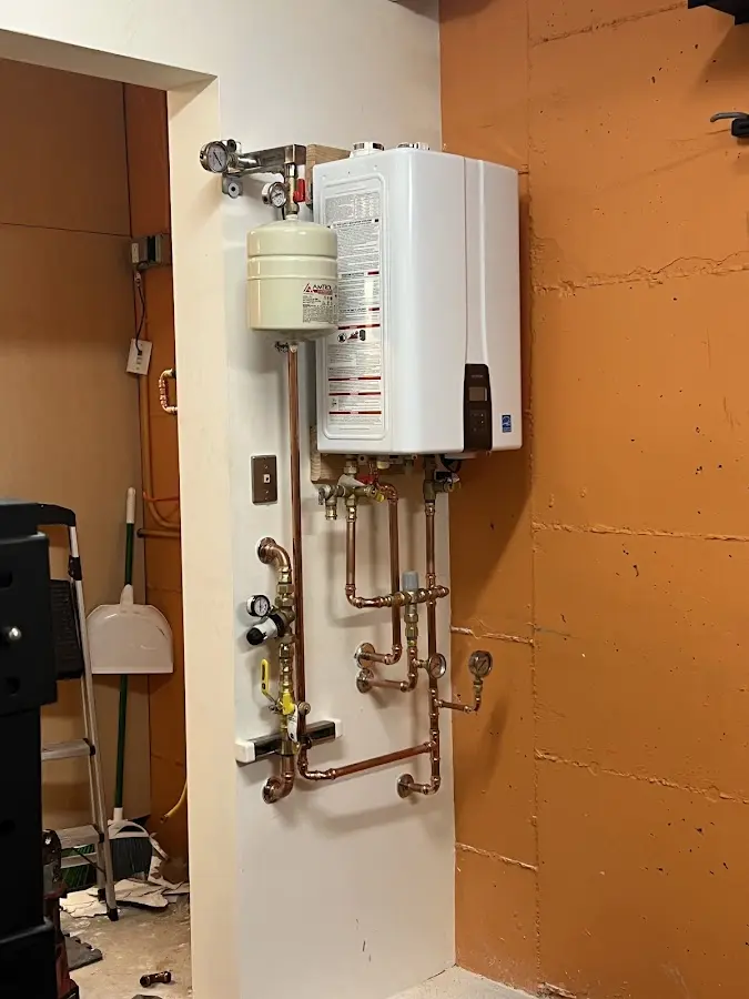 Plumbing technician inspecting water heater connections in New Cumberland